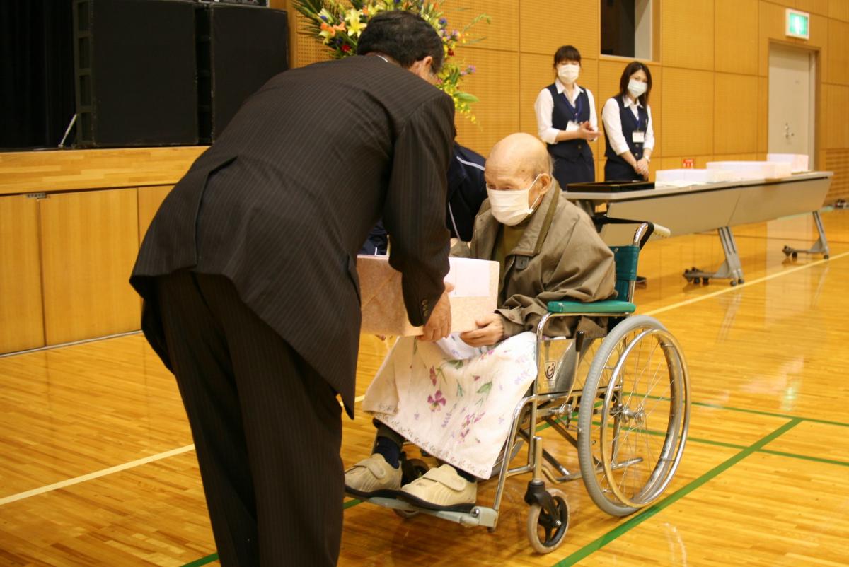 町からのお祝いを受け取る最高齢者の町民