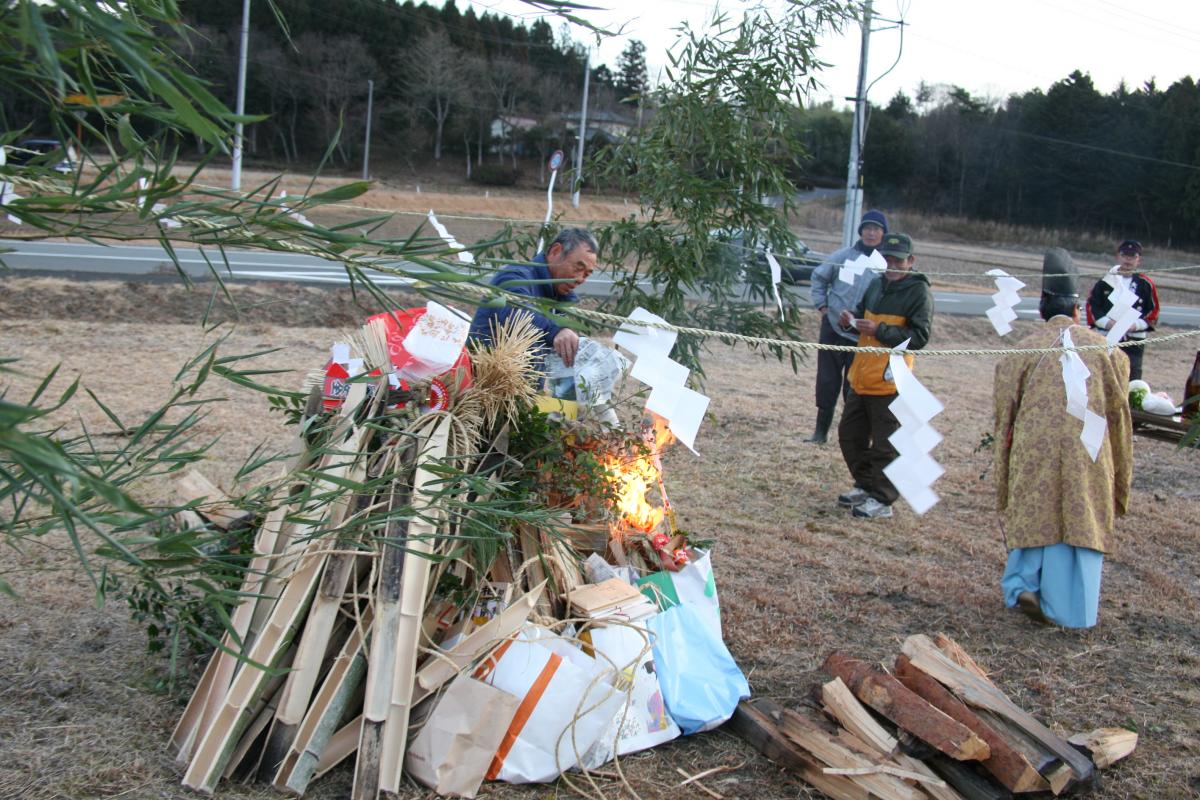 組み上げた正月飾りに火を入れる町民