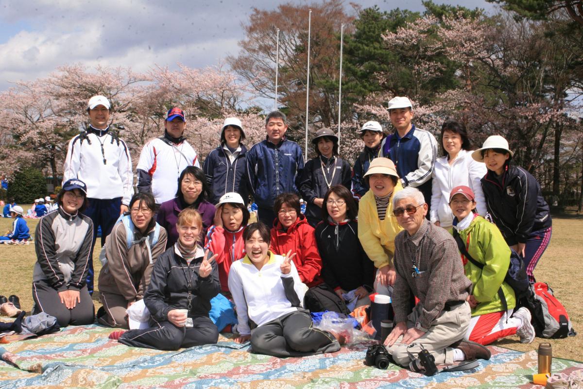 満開の桜の下、記念撮影に収まる先生たち