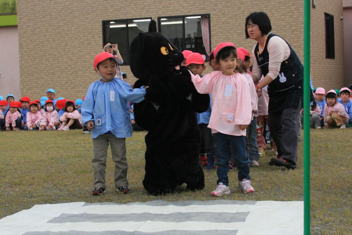 クロネコと手をつなぎしっかり左右を確認する園児