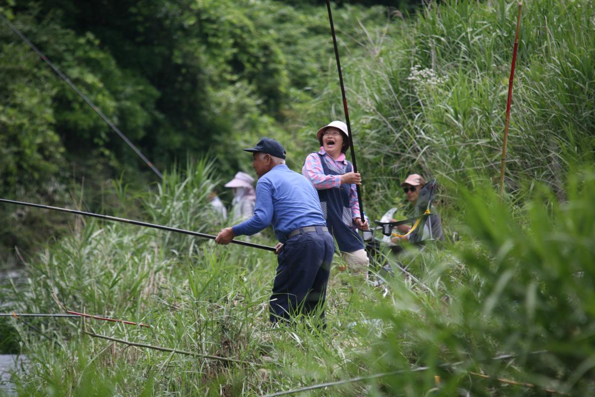 鮎が釣れ大喜びする釣り人