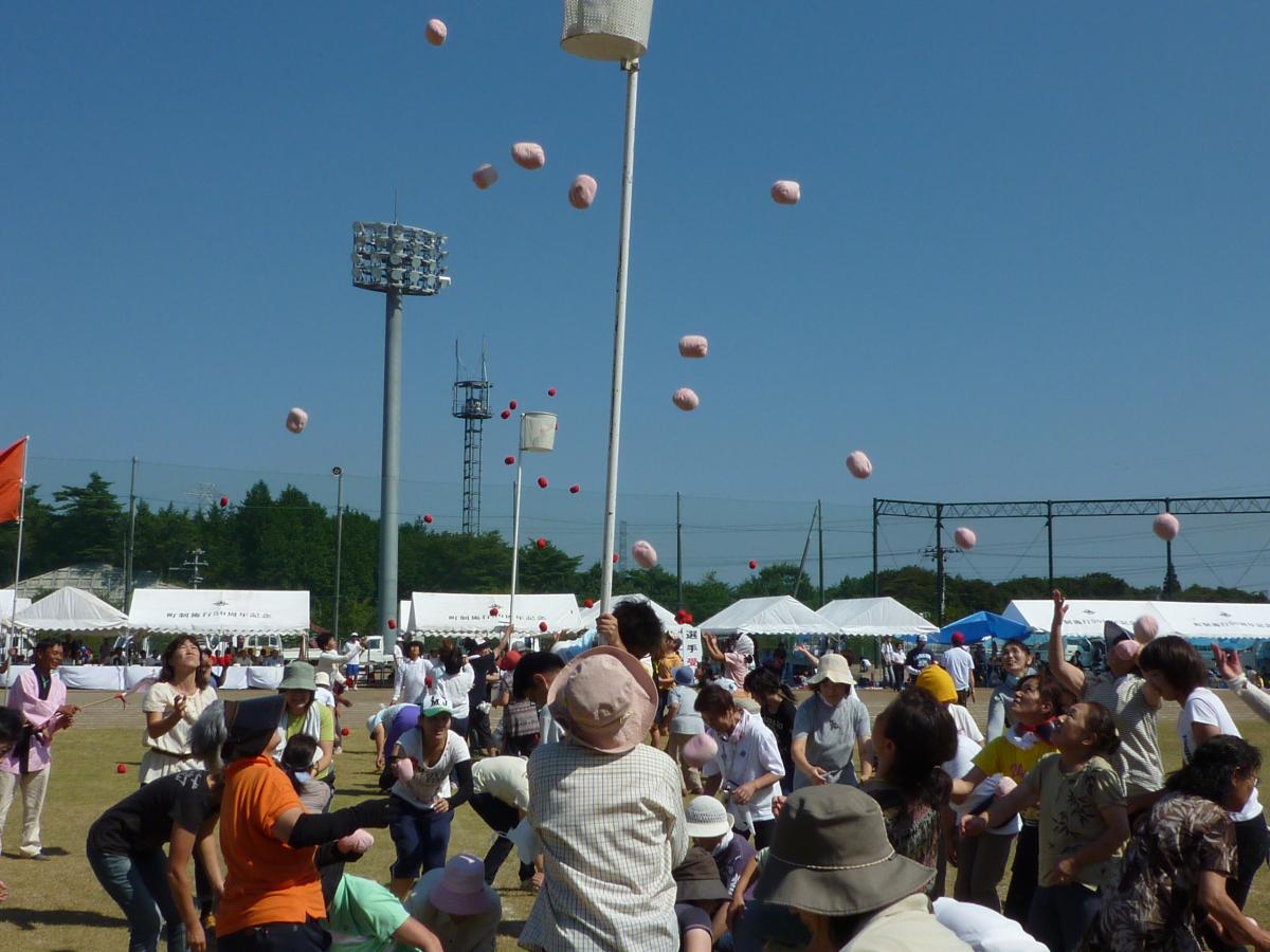 かごを目がけ一斉に玉を投げる町民たち