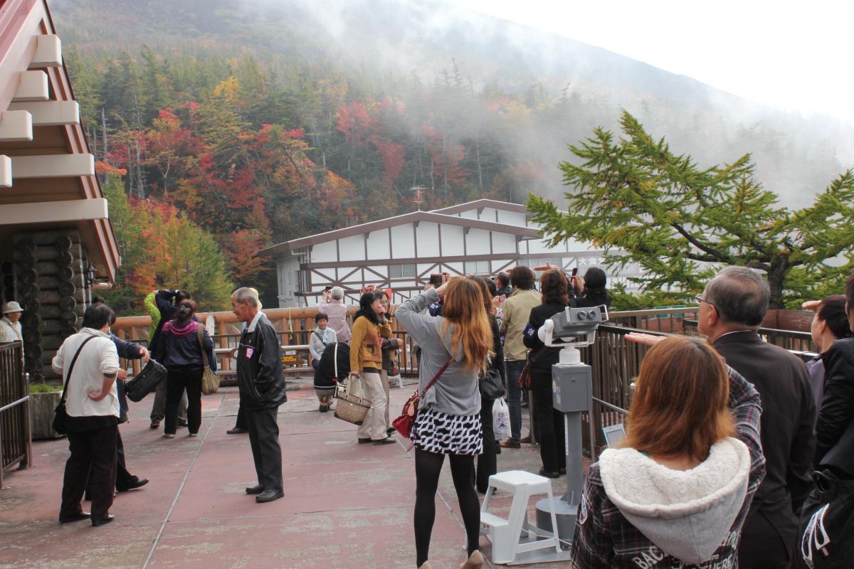 紅葉を迎えた富士山を写真に収める町民