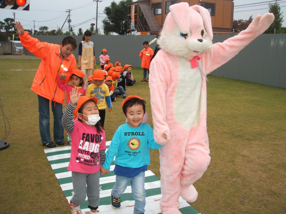 手を上げて模擬横断歩道を渡る子どもたち