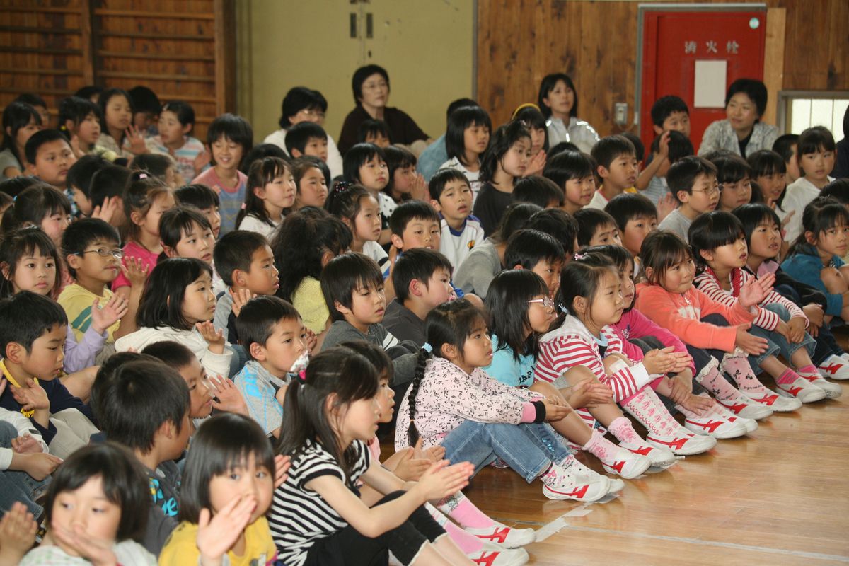 歌に合わせ拍手をして盛り上がる児童たち