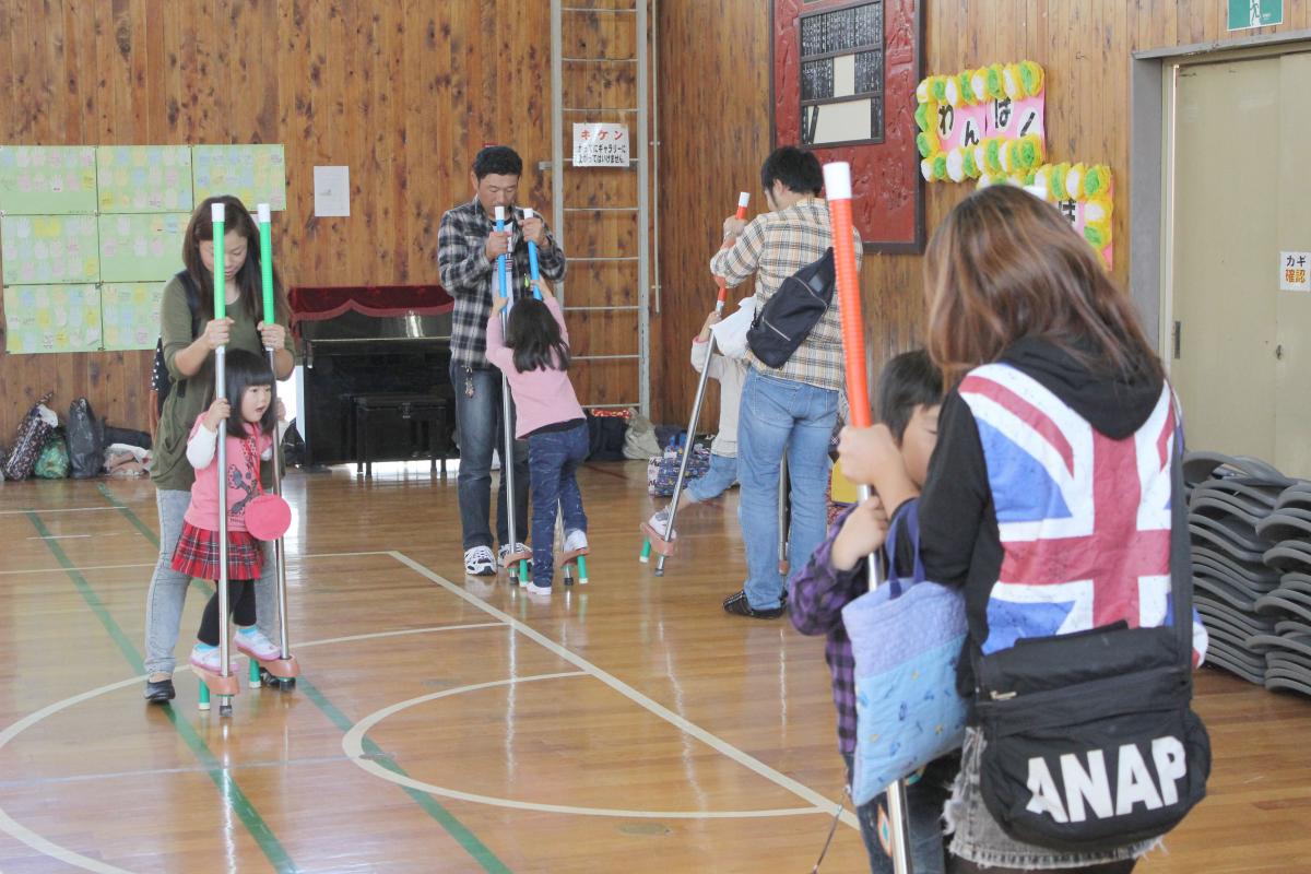 保護者の方と一緒に竹馬を楽しむ園児たち