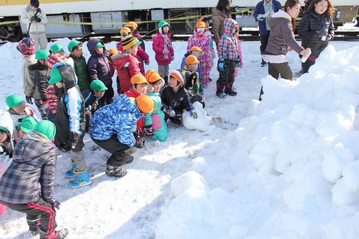 とても大きな雪のかたまりを見つめる園児たち