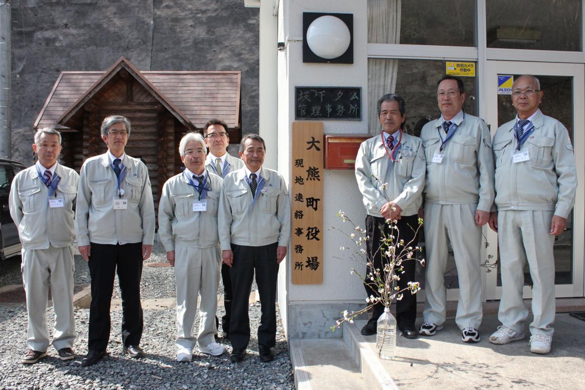 現地連絡所看板前に並ぶ職員