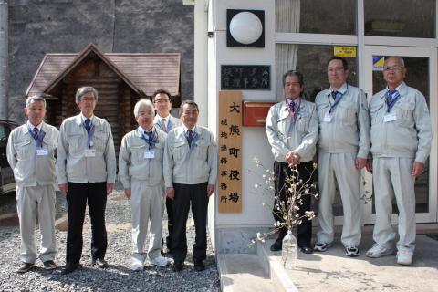 現地連絡所看板前に並ぶ職員