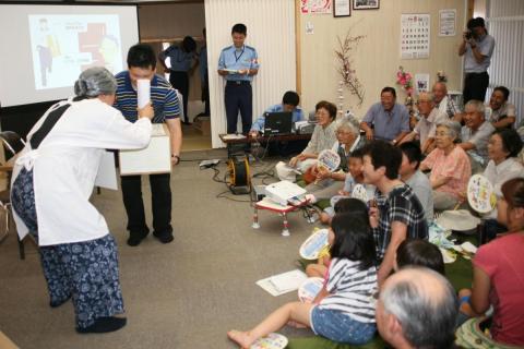 警察官による「送りつけ商法の寸劇」で笑いが起きる会場