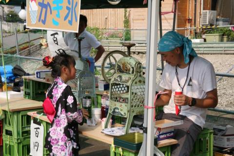 屋台でかき氷を買う浴衣姿の女の子