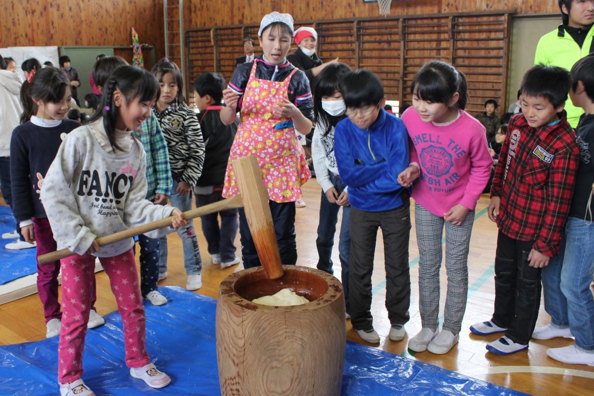 楽しそうにもちつきをする小学生