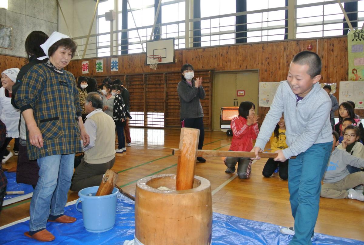 杵をしっかり持ち、楽しそうにもちをつく生徒