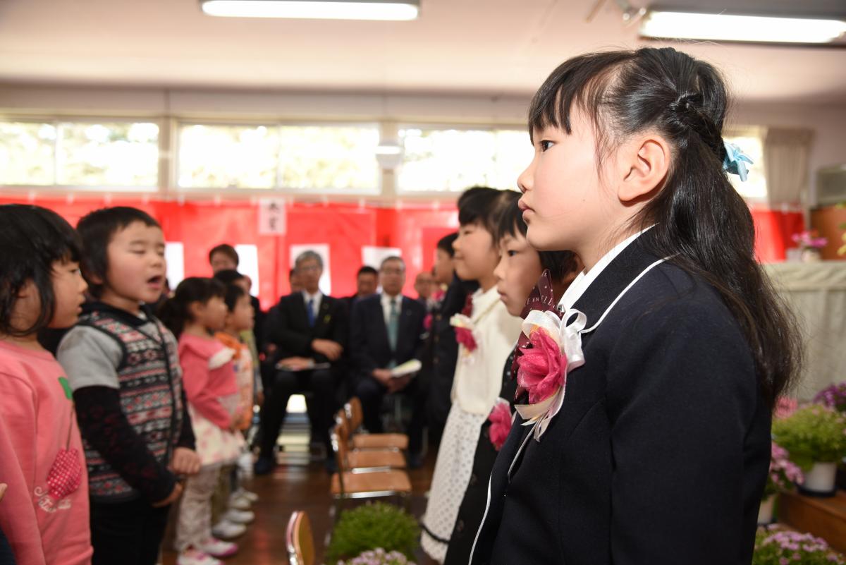 在園児からの歌のプレゼントを聞く卒園児一同