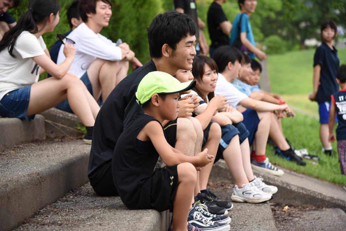 座って話をする学生と参加児童