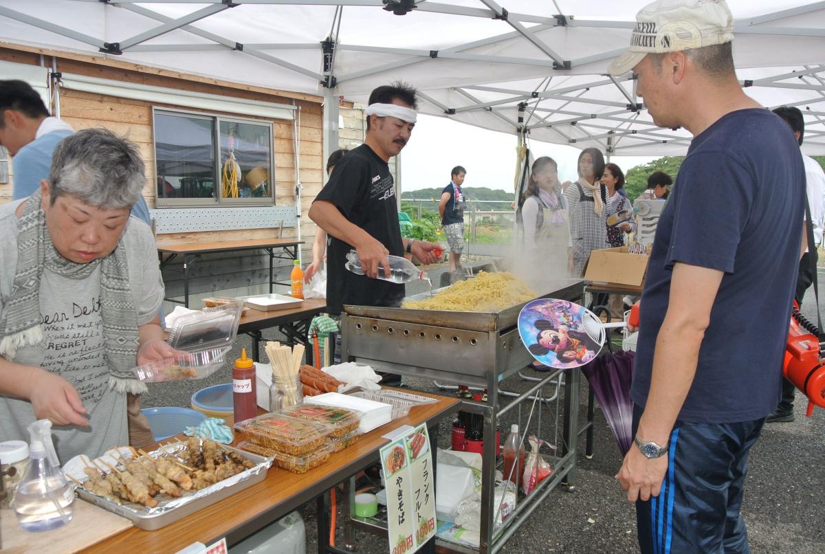 駐車場に例年通り模擬店のテントを並べ、焼そばや焼き鳥を焼く住民