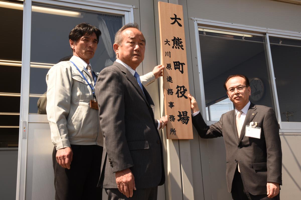 「大熊町役場大川原連絡事務所」の看板を掲げる吉田副町長、鈴木町議会議長、大川原連絡事務所長