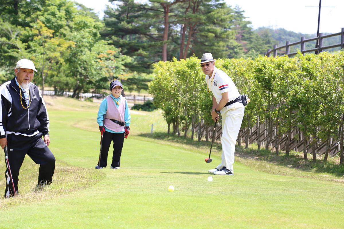 優勝を目指し真剣にプレーする参加者と見守る他の参加者