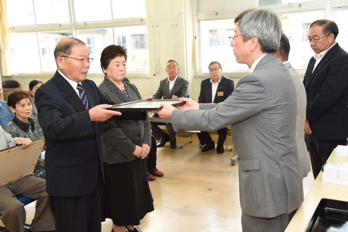 主催する福島民報社の会津若松支店長から表彰を受け、笑顔の金婚夫婦