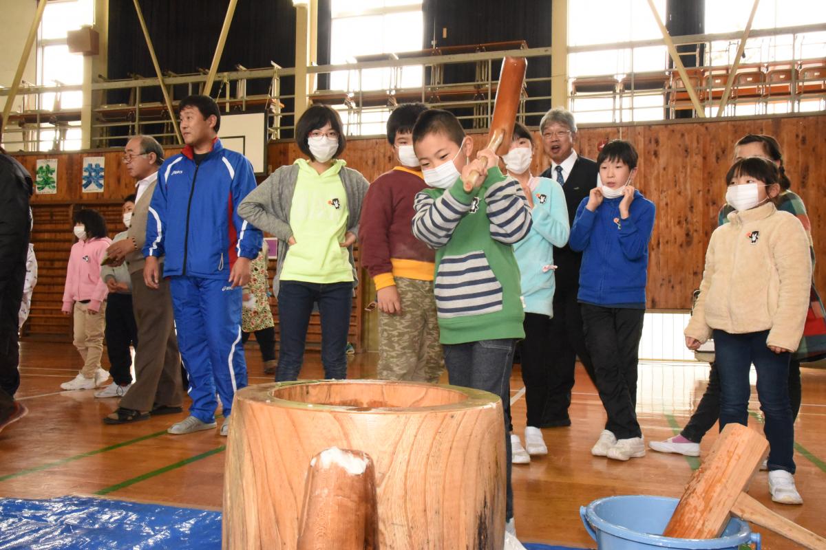 笑顔で餅つきする児童