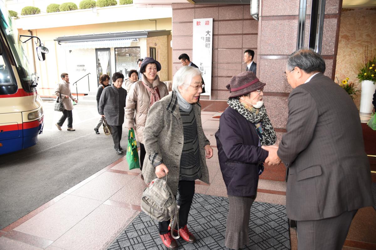 送迎バスから降りて会場に入る参加者