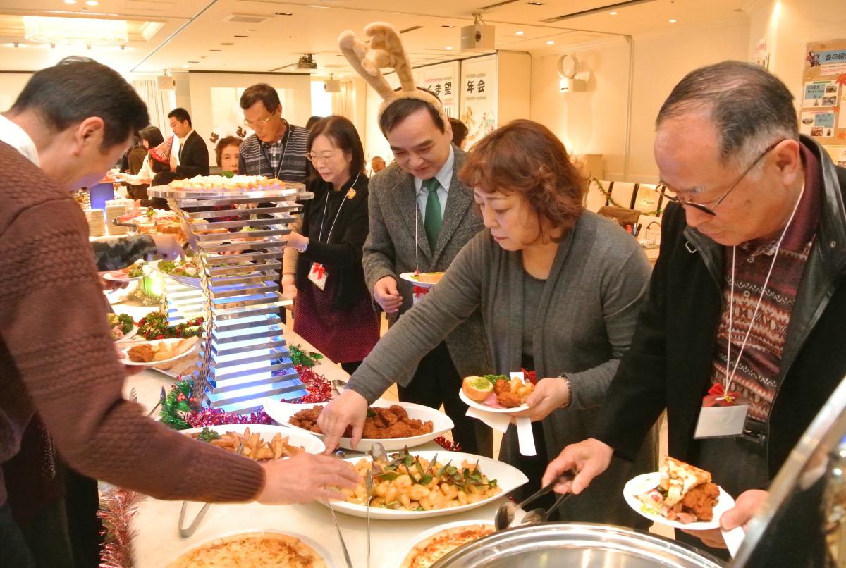 バイキング形式の美味しい料理を前に笑顔の参加者たち