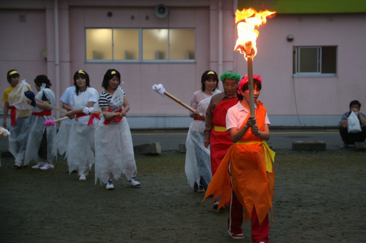 たいまつを持って入場する「火の神」ら