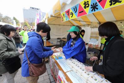 来場者に大熊産のコメを手渡す根本会長