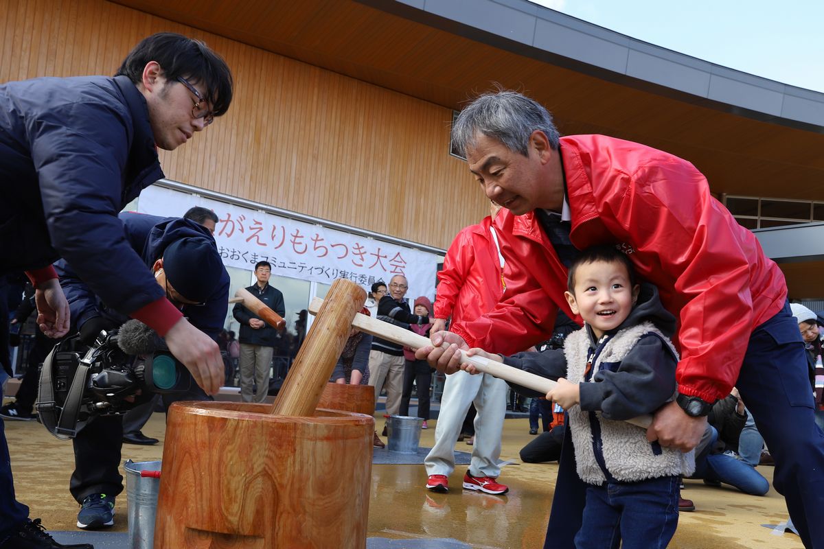 スタッフに支えられながら、にこにこ顔で杵を握る男の子