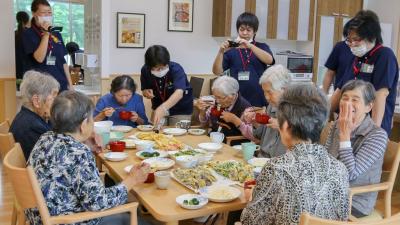 昼食会でそうめんや天ぷらを味わう入居者の皆さん