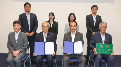 協定書を交わす吉田町長と河野学長（中央左）