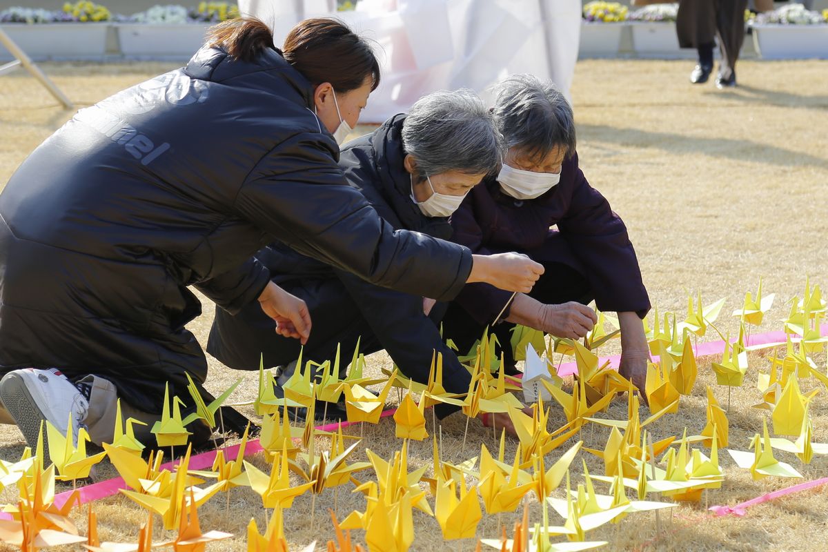 願いを込めた折り鶴を飾り付ける町民