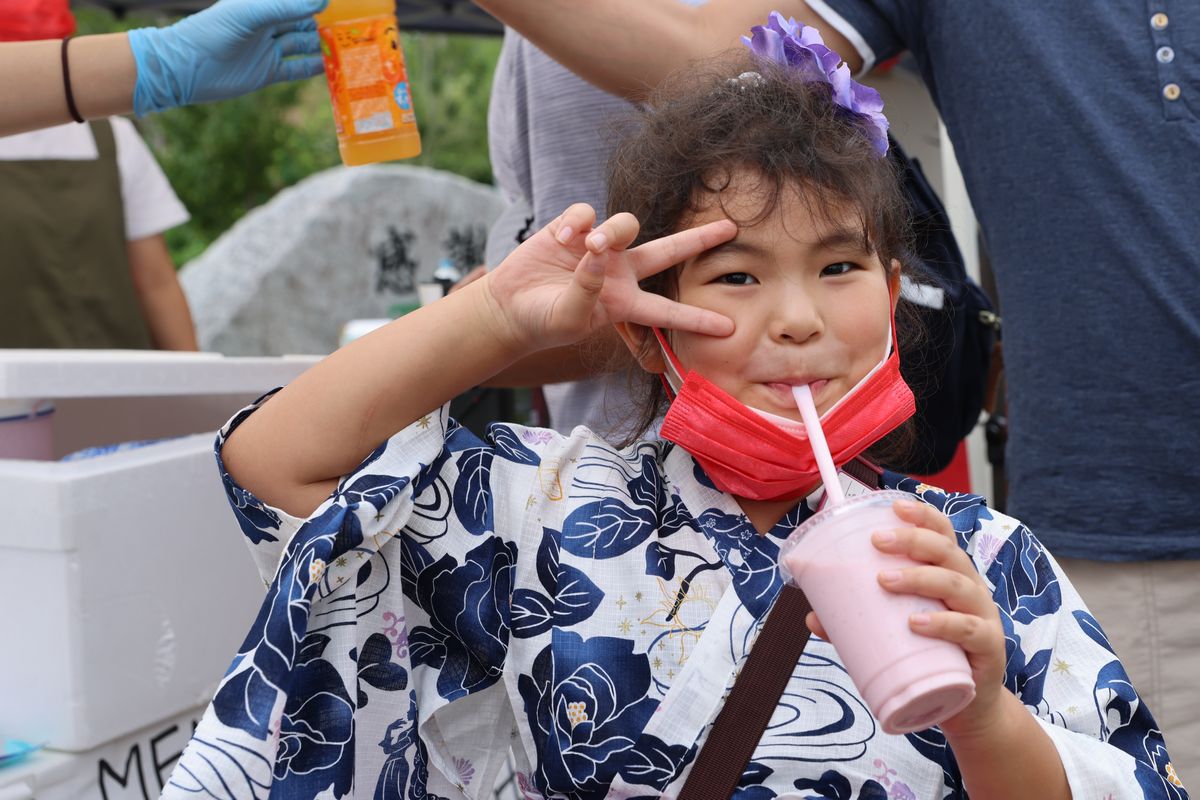 ピースサインをしながら美味しそうにいちごみるくを飲む子ども。