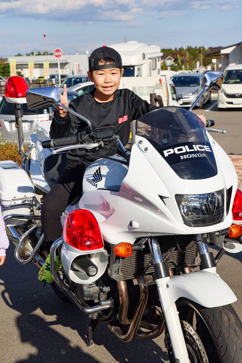 双葉警察署の出展コーナーにはパトカー・白バイの展示がありました。写真は白バイに乗りピースサインをする男児。