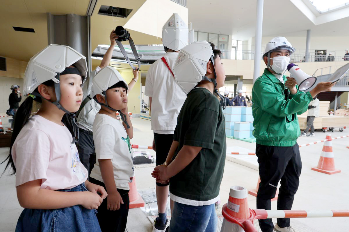 校舎内に入ると、子どもたちは吹き抜けになっている 図書ひろばの広さに驚いて歓声を上げました。