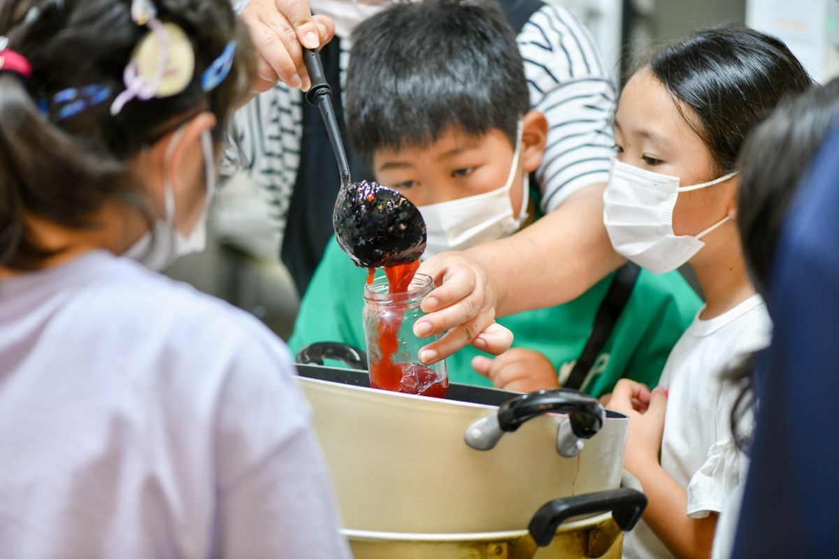 粗熱が取れたイチゴジャムは、各自が用意した瓶に詰められます。子どもたちは説明をしてくれたスタッフの手元をじっと見つめます。