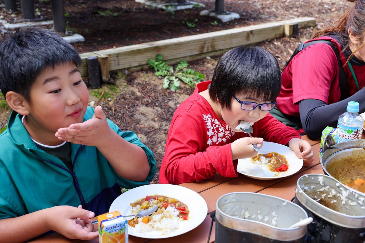 完成したカレーライスを食べる児童ら