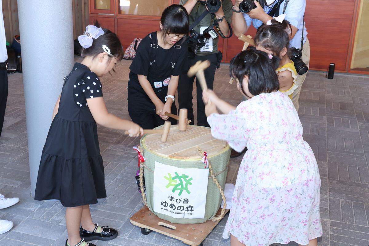 8月25日、第2学期始業式の前に新校舎との対面式が開かれ、登校した子どもたちがメインエントランス前で鏡開きを行いました。