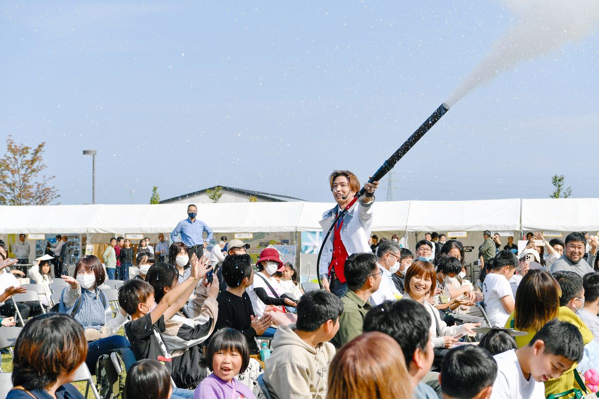 市岡元気さんが科学実験で降らせた雪に歓声をあげる来場者ら