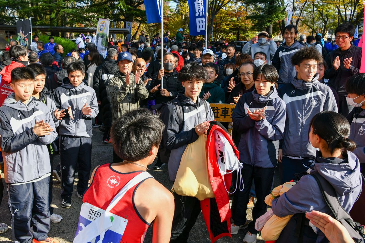 拍手でアンカーの吉田好孝選手を迎えた選手ら