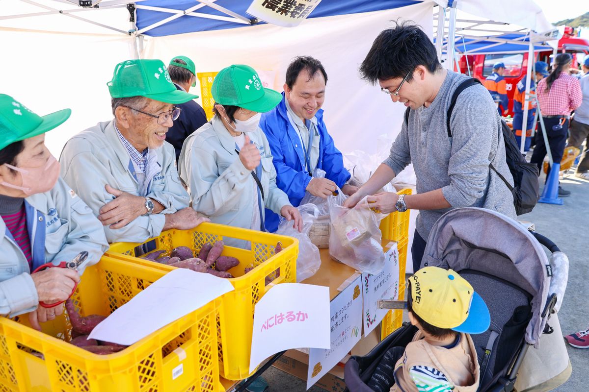 町農業委員会は町内大川原地区で栽培したサツマイモ「紅はるか」と「シルクスイート」の2種類と町内産コシヒカリを無料配布しました。喜ぶ来場者に農業委員会のメンバーも笑みがこぼれます。