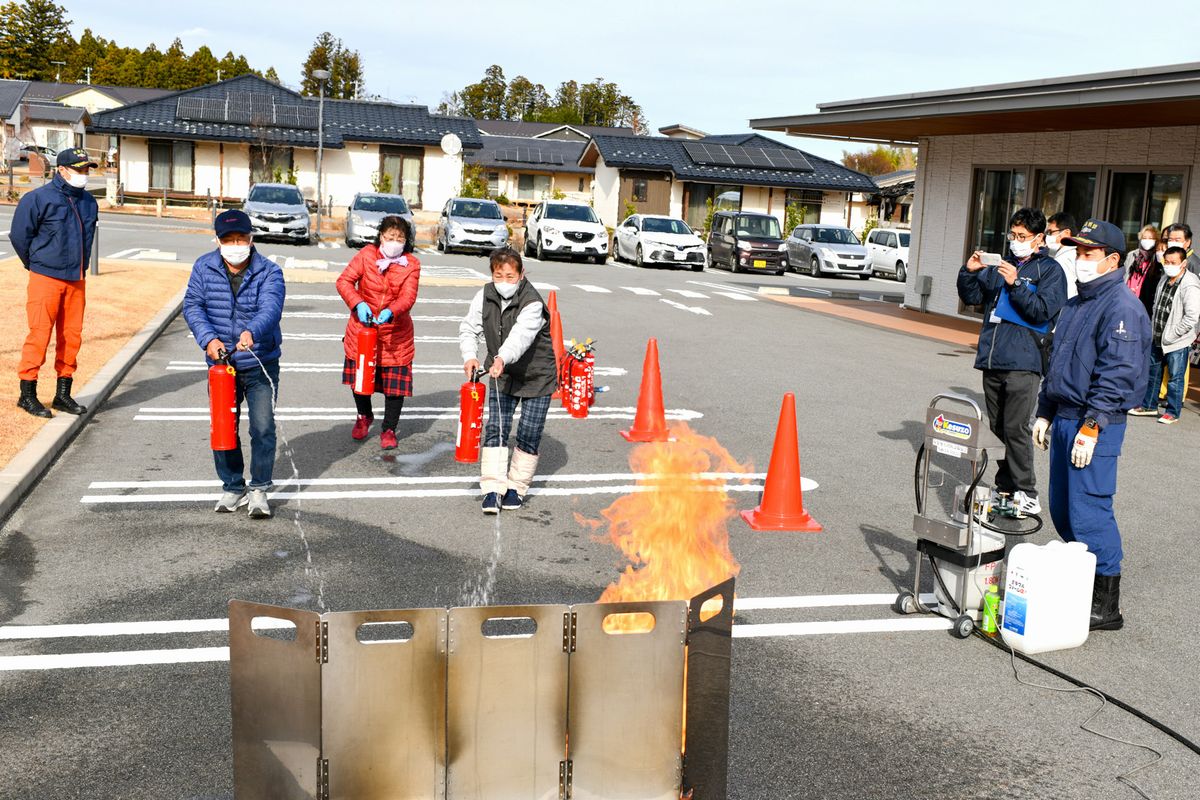 消火訓練の指導を受ける参加者ら