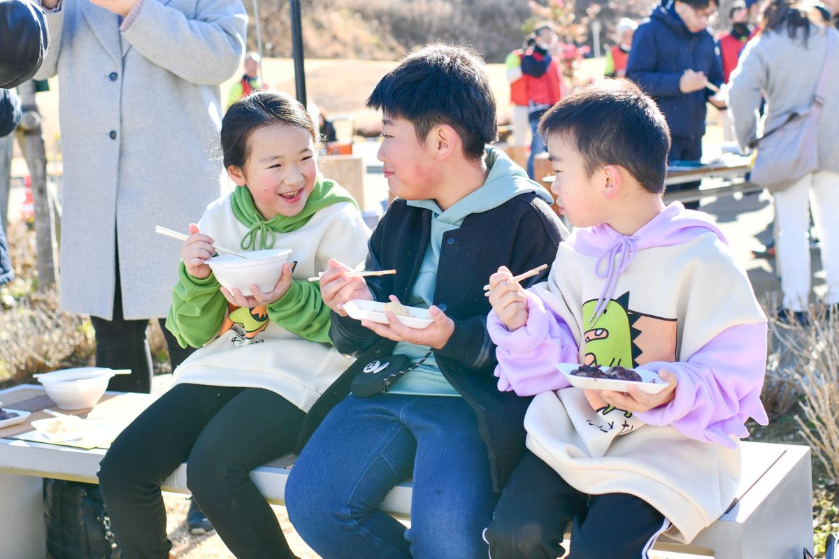 配られた餅を食べる子どもたち