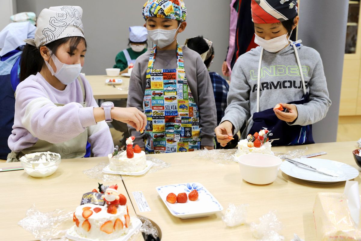 ケーキの飾り付けをする子どもたち。友だちの飾り付けも気になります。