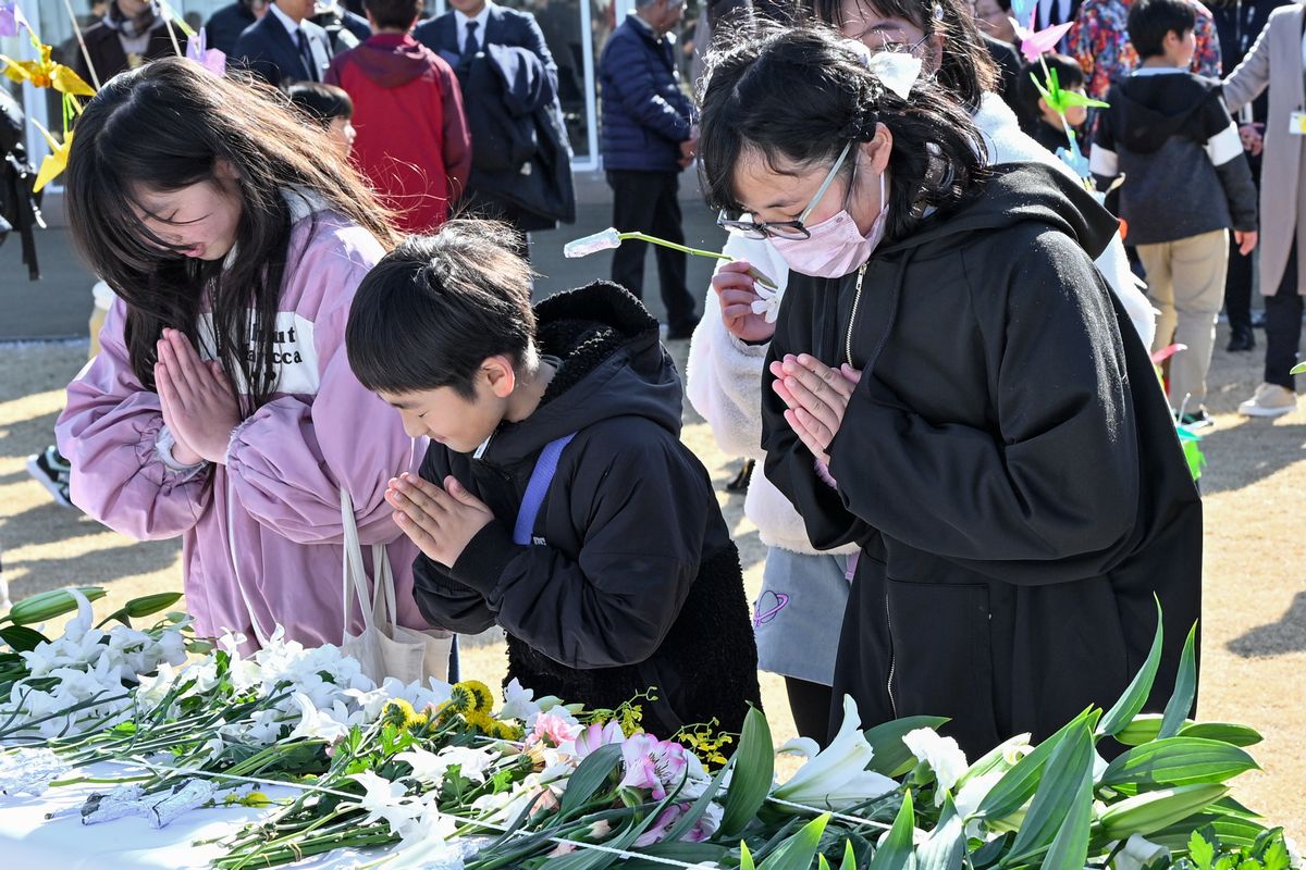 花を手向け祈りを捧げる学び舎ゆめの森の子どもたち