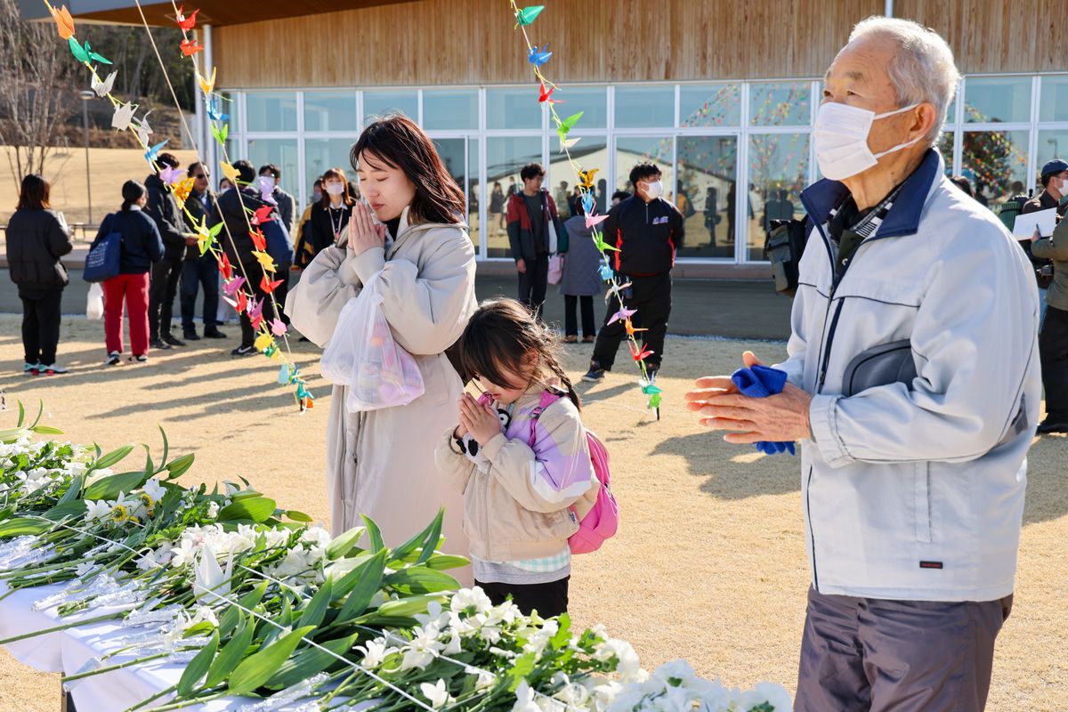 献花台の前で祈る町民ら