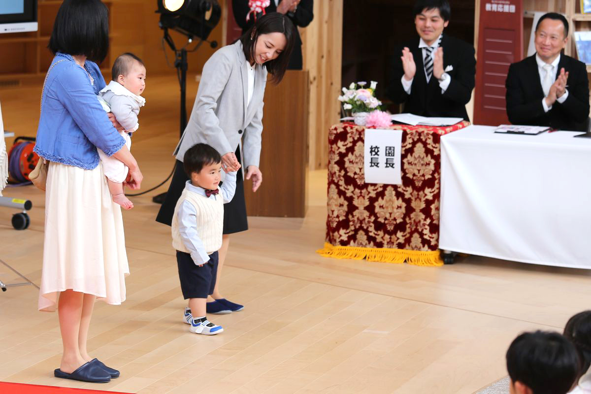 保育部の新入園児は保護者に抱っこされたり、手を繋いだりしながら入場。正面ステージに立つと堂々と顔をみせてくれました。