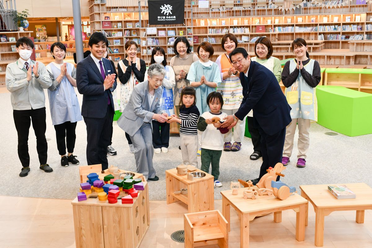 木のおもちゃを受け取る代表園児ら（中央）