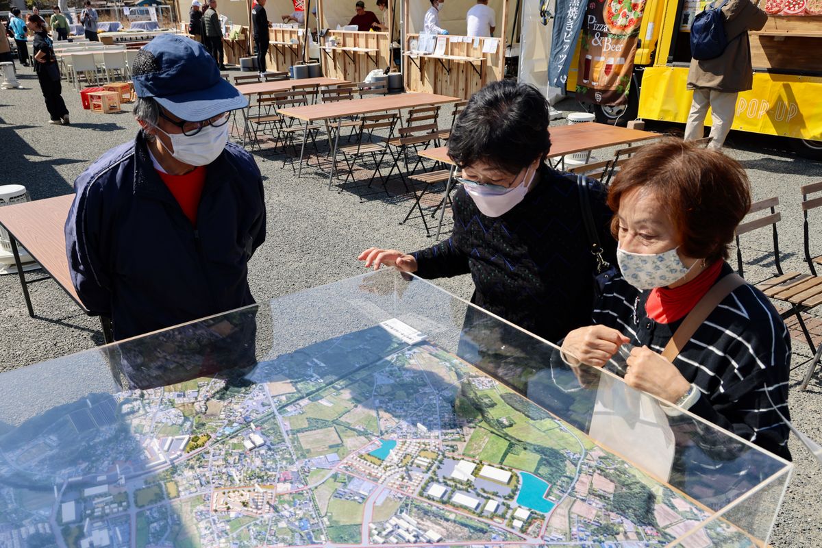 大熊町下野上地区の建築模型を見る来場者。