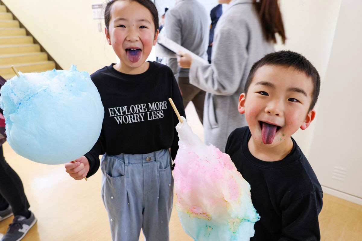 色の付いた綿菓子を食べ、はしゃぐ子どもたち